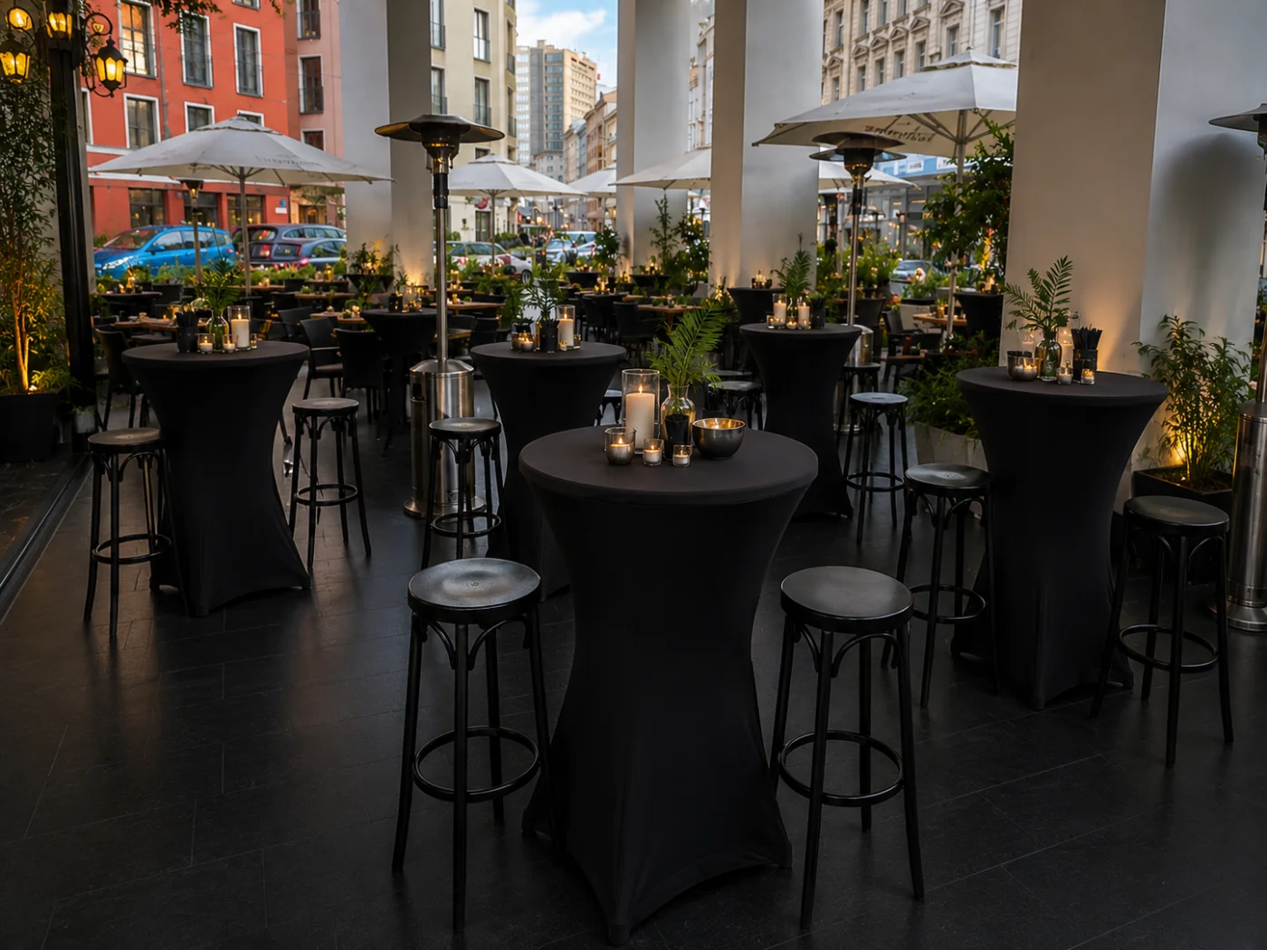 Abend-Stehempfang im STORIA München — elegantes Event-Setup mit schwarzen Stehtischen und Kerzenbeleuchtung auf der Loggia